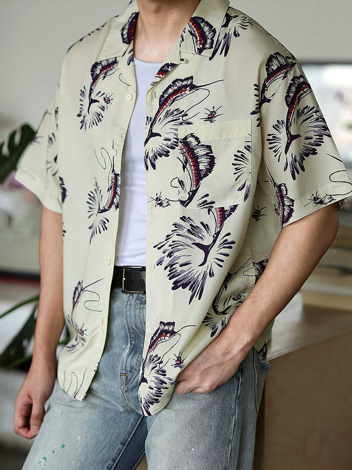 モデルがカジキプリントのハワイアンシャツを着用し、リラックスした夏のスタイリングを展示しています。