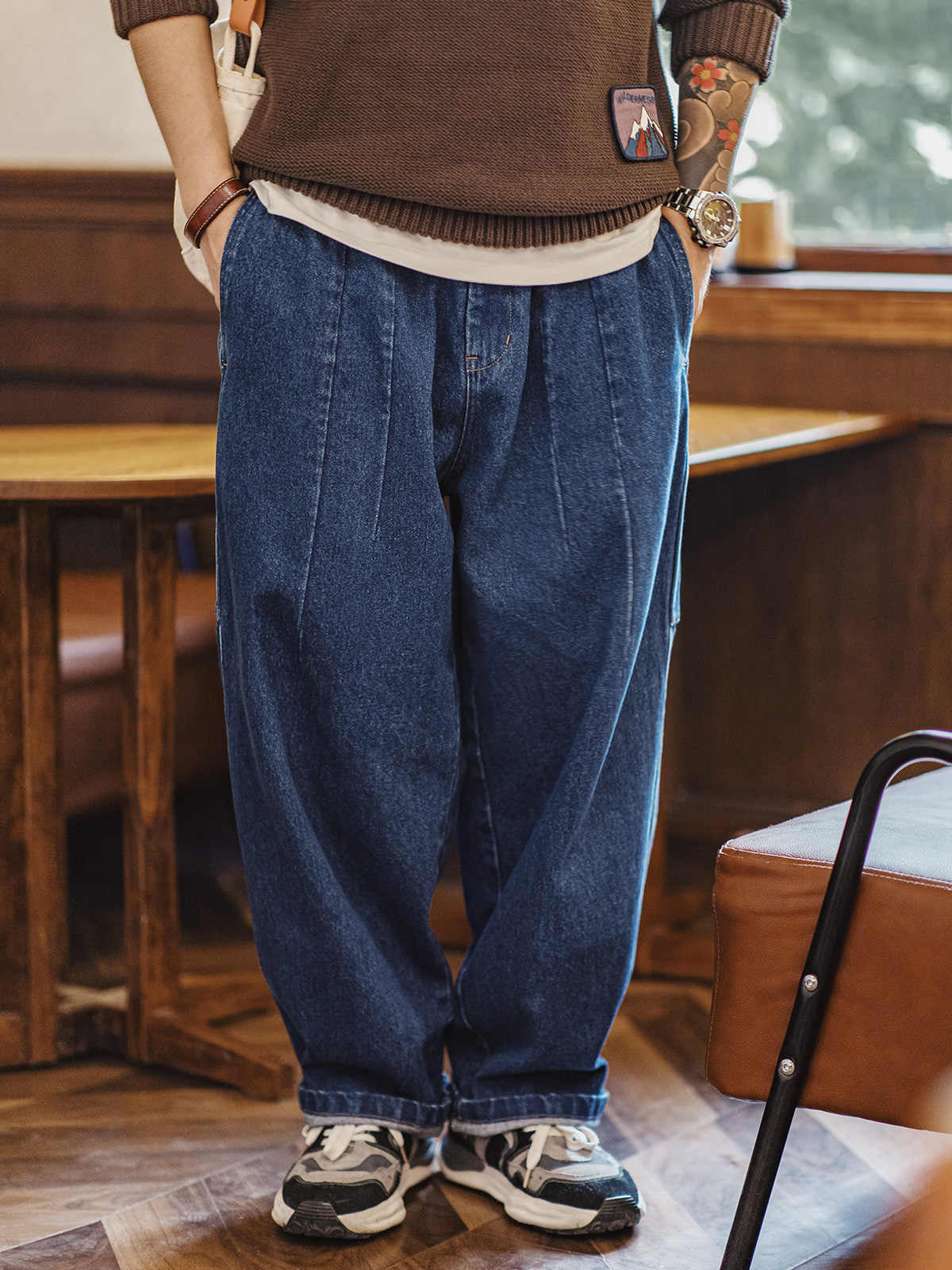 詳細画像
ウォッシュドカーペンタージーンズのディテール画像。A面のプリーツデザインとB面の多機能ポケットの近接ショットで、独特の質感と実用性を紹介。
モデル画像
レトロなルーズフィットのウォッシュドカーペンタージーンズを着用したモデルの画像。カジュアルスタイルや通勤スタイルでの着こなし例を示し、リバーシブル仕様の多用途性をアピール。