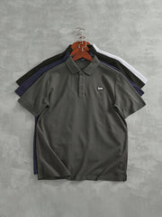 ポロシャツのリブ編みの襟とシンプルなアルファベットワッペンの詳細