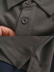 ポロシャツのリブ編みの襟とシンプルなアルファベットワッペンの詳細