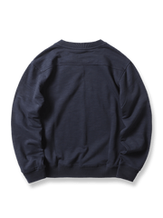 製品画像: ネイビーのアンカー柄エンブレムが施されたクルーネックプルオーバー長袖スウェットシャツの正面画像。ミリタリーデザインと100%コットン素材の特徴を表示。
詳細画像: ネイビーのアンカー柄エンブレムのディテール画像。スウェットシャツの質感とエンブレムのクローズアップ。
