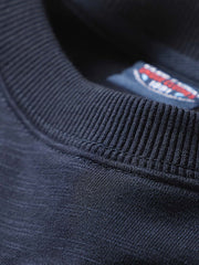 製品画像: ネイビーのアンカー柄エンブレムが施されたクルーネックプルオーバー長袖スウェットシャツの正面画像。ミリタリーデザインと100%コットン素材の特徴を表示。
詳細画像: ネイビーのアンカー柄エンブレムのディテール画像。スウェットシャツの質感とエンブレムのクローズアップ。