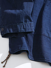 製品画像:ウォッシュデニムのルーズフィットブレザー正面展示。シンプルながら個性的なデザインが特徴。
詳細画像:波模様の裏地と襟元のアウトドア風ボタンディテール。控えめな個性が光るディテール。