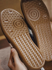 地心引力トレーニングシューズの耐摩耗性ゴム製アウトソールとカラーブロックのクローズアップ。細部にわたる質感と構造の精緻さを強調。