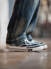 モデルが着用するウォッシュデニムと刺し子布のカジュアルシューズ - ヴィンテージファッションを強調