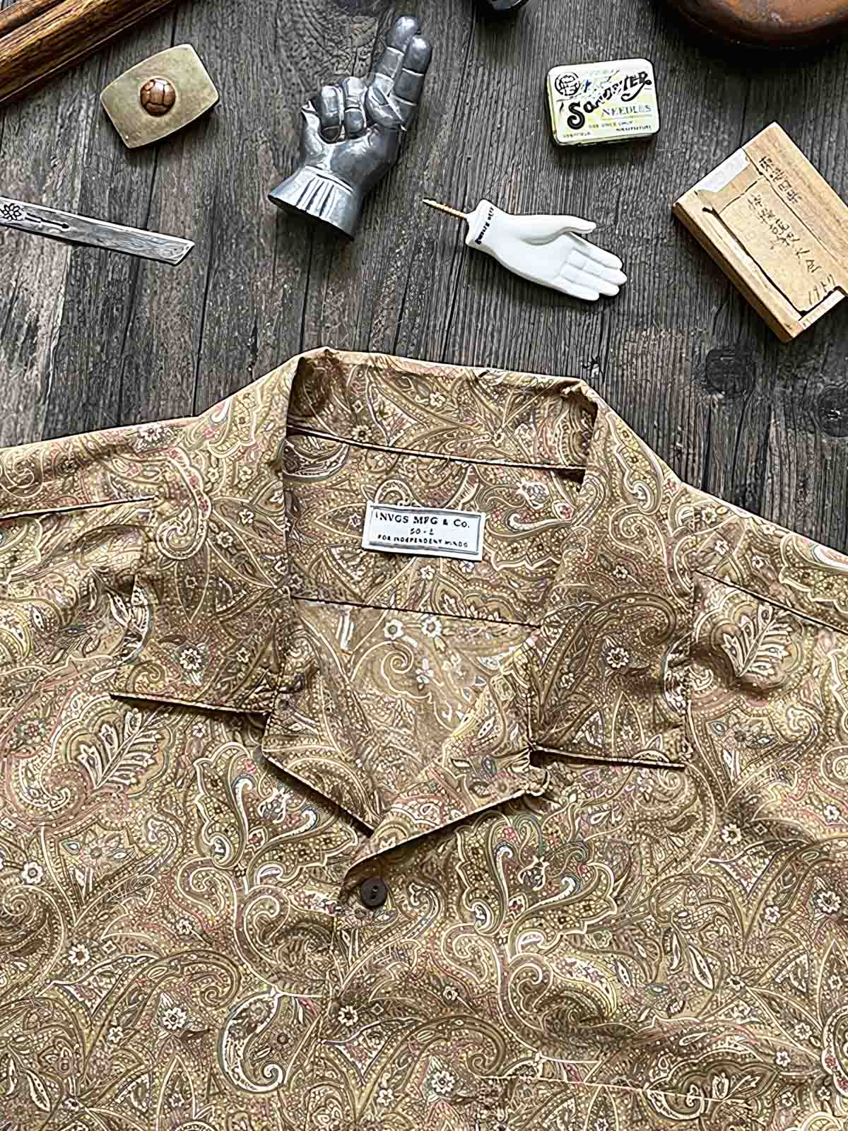 シャツのペイズリー柄生地とココナッツシェルボタンのディテール