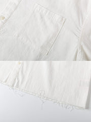 シャツのディストレストリムデザインとウォッシュドディテールのクローズアップ