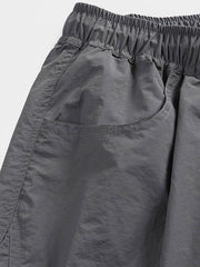 非対称パッチワークナイロンショーツの詳細クローズアップ。耐久性と速乾性に優れた100%ナイロン素材を使用し、独創的なデザインの特徴を強調しています。」