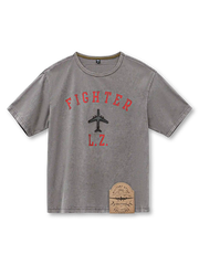 ウォッシュグレーのTシャツ、胸に赤いアーチ文字と機影のプリント、裾の古風なパッチ付き