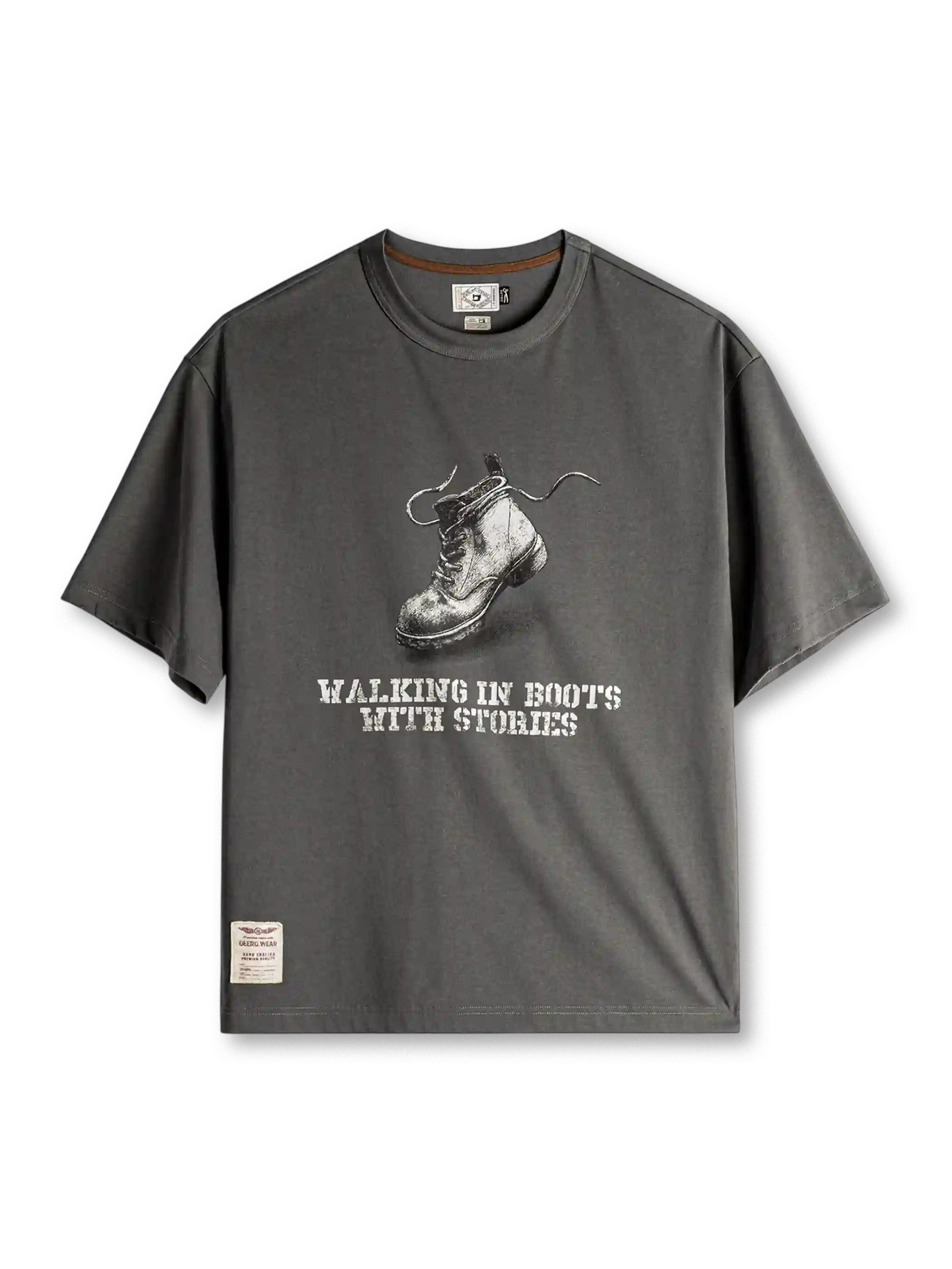 ダークグレーのTシャツ、胸に素描風のワークブーツとステンシル風の英字プリント、裾のラベル付き