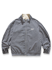 ベージュとヴィンテージチェック柄のリバーシブルスタンドカラージャケット。防風性と快適なフィット感を兼ね備え、春の多様なシーンで活躍する軽量中厚素材使用。