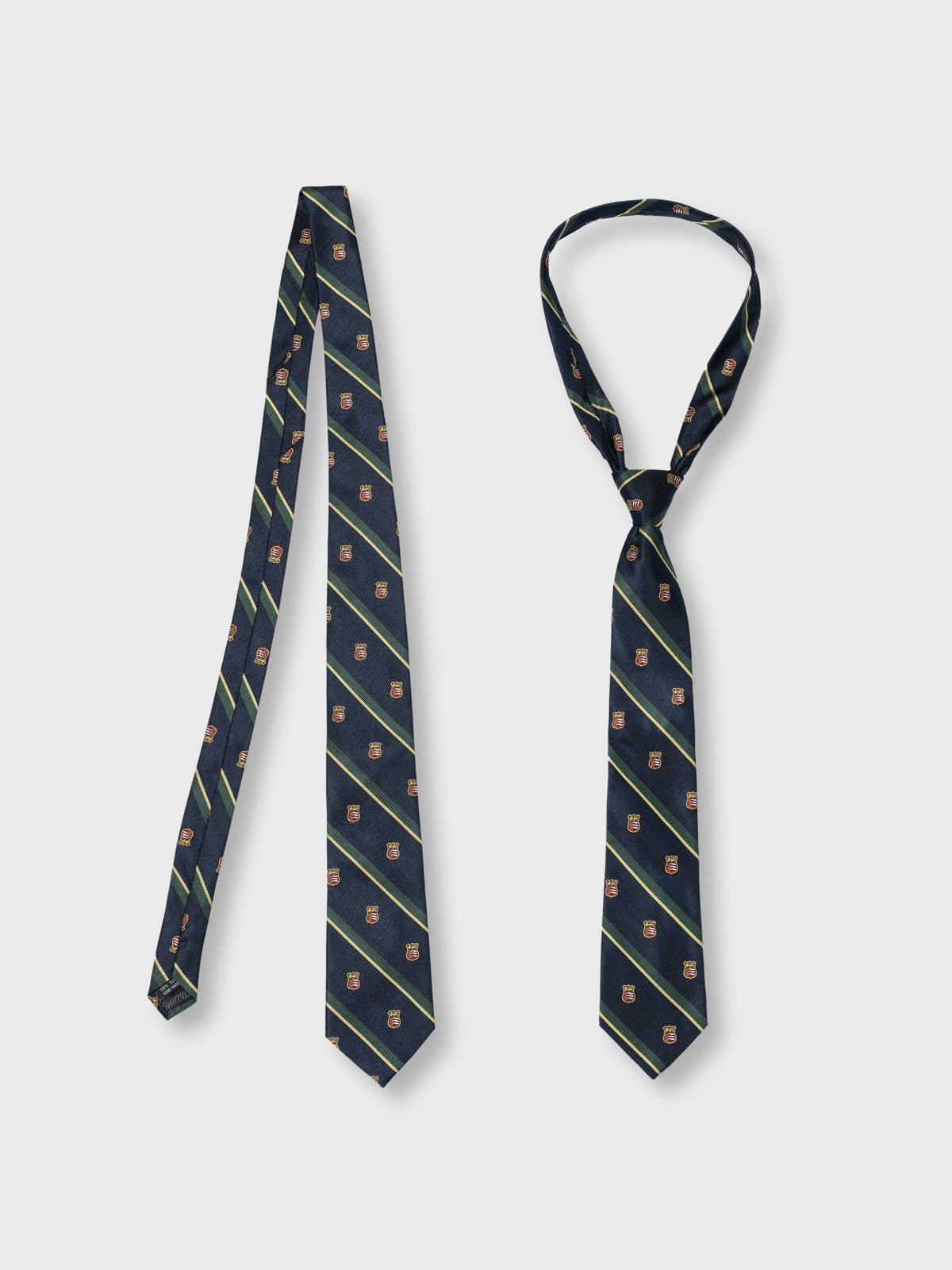 シールドモチーフとブルーグリーンストライプが特徴のシルクネクタイ