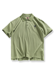 スケートボードを楽しむ少年の刺繍が入ったポロシャツ。