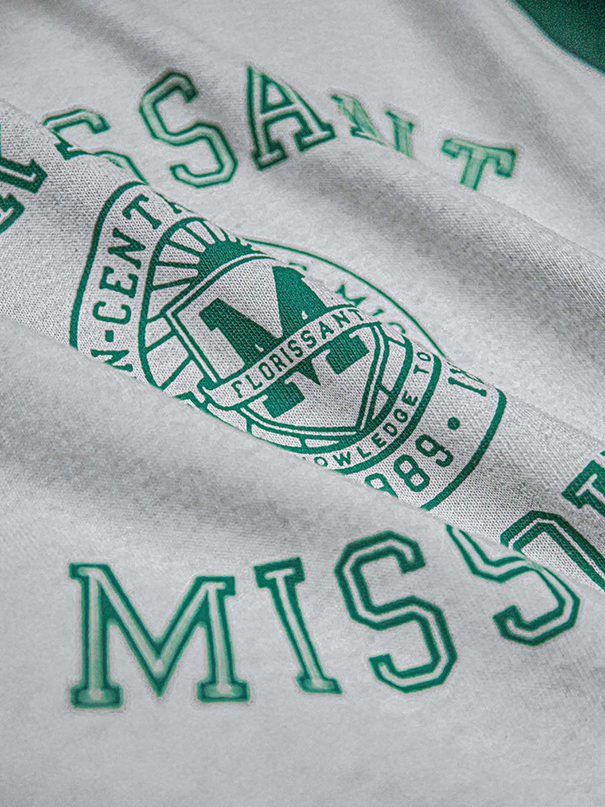 詳細画像:Tシャツのエンブレムプリントと配色袖口のディテール