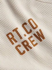 ワッフルプリント長袖Tシャツの胸元プリントとセミハイネックのクローズアップ。細かいディテールが特徴で、上品かつカジュアルなスタイルを提供します。