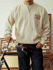 モデルがワッフルプリントの長袖Tシャツを着用し、ジーンズとカジュアルシューズでスタイリング。秋のキャンパススタイルや週末のカジュアルな装いに最適です。