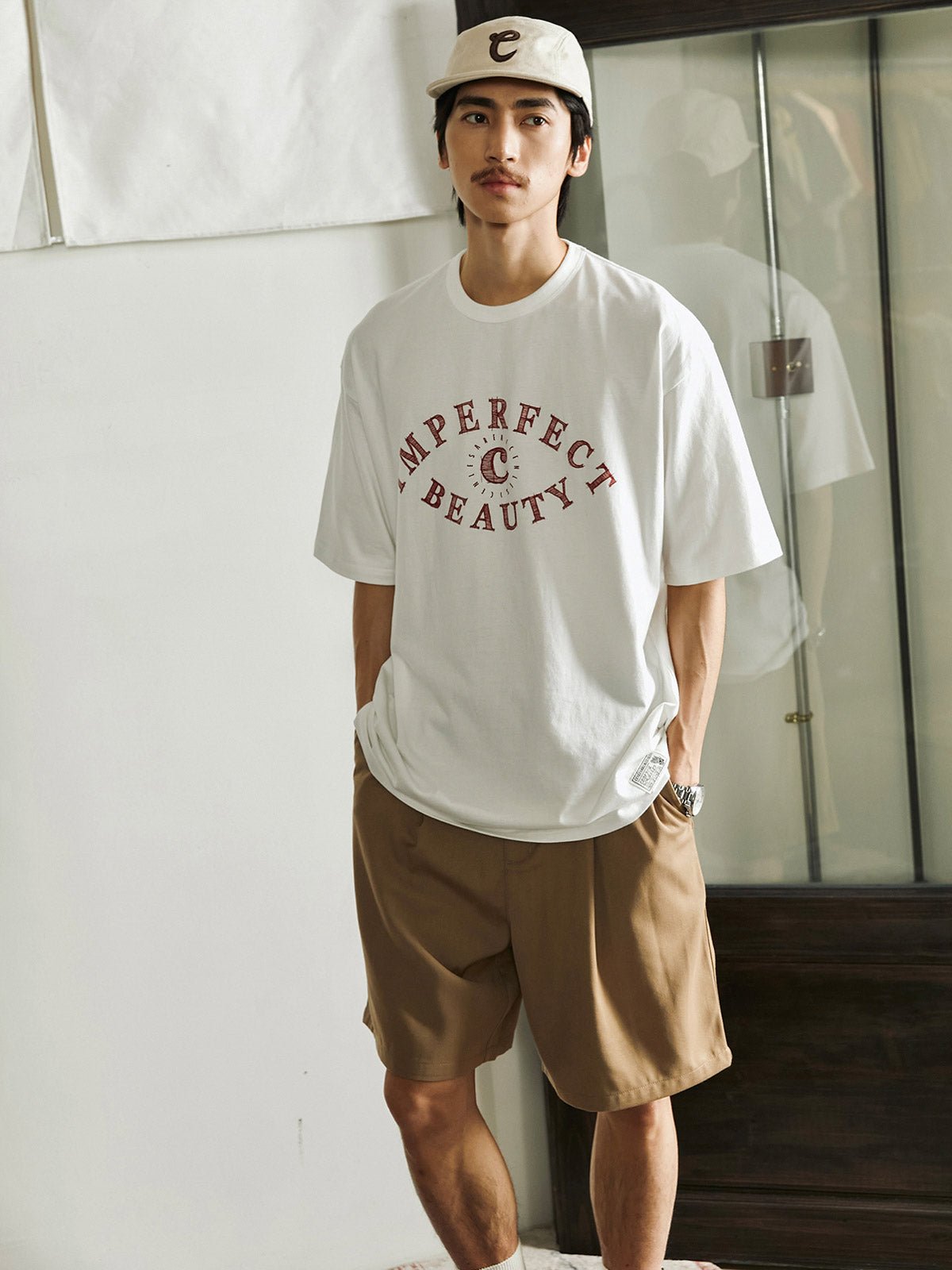 ディスカバリーの目」テーマの純綿Tシャツを着用したモデルが、カジュアルなスタイルで着用する様子を披露しています。