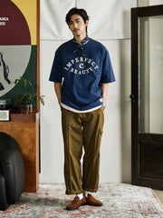 ディスカバリーの目」テーマの純綿Tシャツを着用したモデルが、カジュアルなスタイルで着用する様子を披露しています。