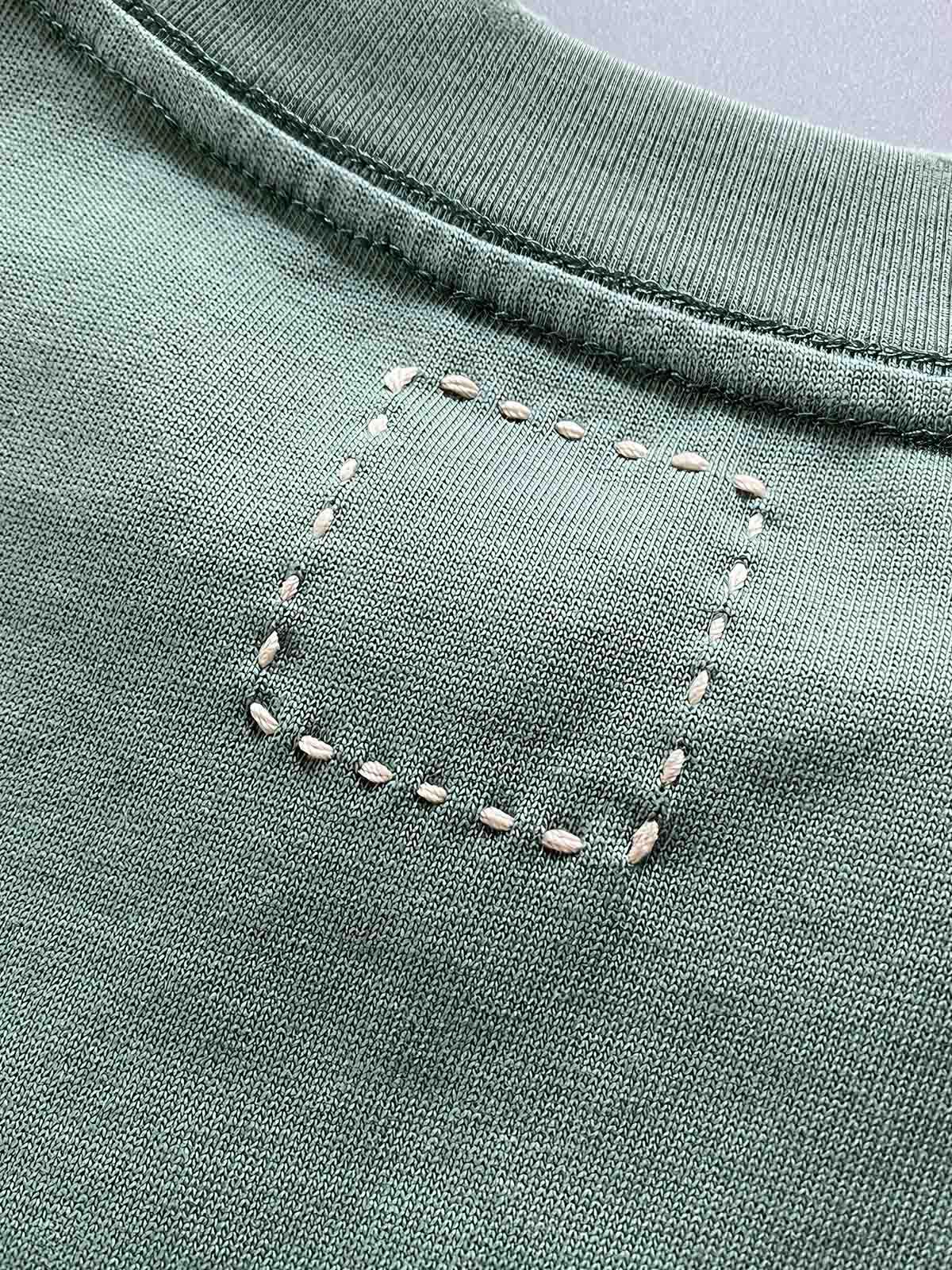 製品画像: 320gのヘビーウェイトコットンウォッシュポケット付きショートスリーブTシャツの全体像
詳細画像: 胸元のポケットとウォッシュ加工によるディテールを強調したショット