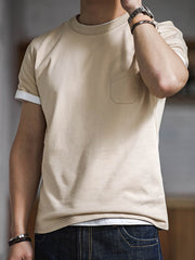 モデルがトリプルステッチポケット付きコットンTシャツを着用し、カジュアルパンツとシンプルなスニーカーでスタイリング。日常の着用やカジュアルなシーンに適しており、リラックスしたスタイルを提案しています。