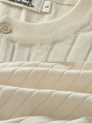 ヘンリーネックのボタンディテールとニットテクスチャのクローズアップ。