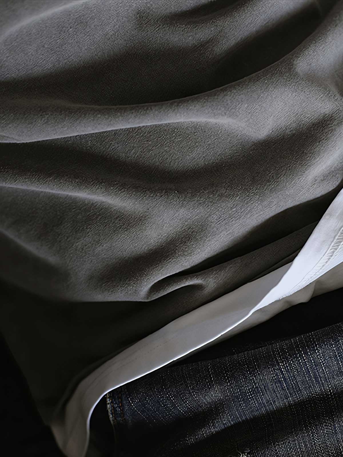 製品画像: インディゴウォッシュのヴィンテージ風長袖Tシャツの正面展示
詳細画像: Tシャツの襟元と袖口の三角カットディテールのクローズアップ