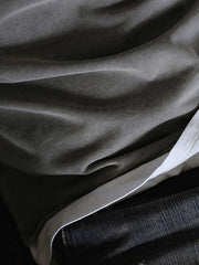 製品画像: インディゴウォッシュのヴィンテージ風長袖Tシャツの正面展示
詳細画像: Tシャツの襟元と袖口の三角カットディテールのクローズアップ