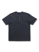日本製の丸筒織機で編まれた厚みのある生地のヘンリーネックTシャツ。三つの貝ボタンと落ち肩のスタンダードフィットで、リラックス感と耐久性を兼ね備えたデザイン。