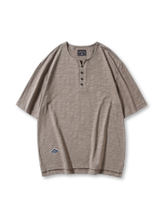 伝統的なヘンリーネックデザインを持つスラブコットン素材のルーズフィットTシャツ