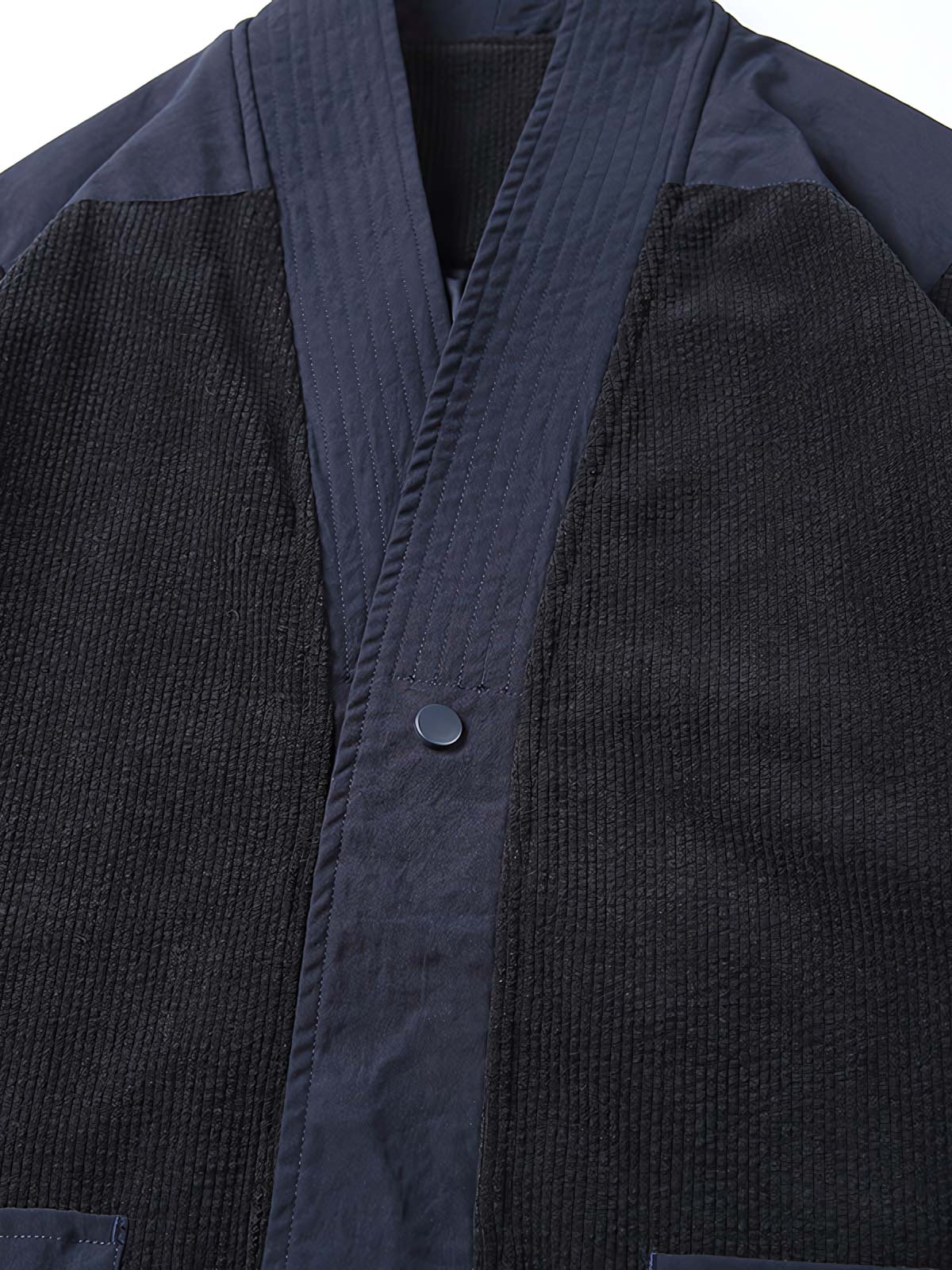 ジャケットの大ポケットとVネックカラーブロックデザインのディテール