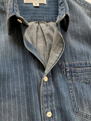 ウォッシュ加工を施したクラシックなデニム生地と緻密なストライプデザインのディテール。耐久性と洗練された印象を提供。