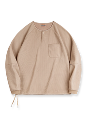 立体感のあるワッフル編み素材を採用したヘンリーネックシャツの全体画像。ヴィンテージ感あふれるY字型ボタン付きデザインが特徴で、日常のカジュアルコーデやレイヤードスタイルにも最適。
詳細画像
幾何学模様のワッフル編みテクスチャー、袖口のリブディテール、裾のドローストリングデザインを強調したクローズアップ画像。ラグランスリーブと切り替えデザインが動きと立体感を演出。