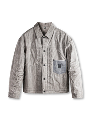 グレー系のワックスドコットン製タイプIジャケット、フロントボタン仕様、胸にパッチポケット付き
