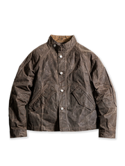 スタンドカラーとワックスドキャンバス素材を特徴とするヴィンテージミリタリースタイルのジャケット。肘の補強ステッチと実用的なスラントポケットを備え、防風・防水性に優れたデザイン。