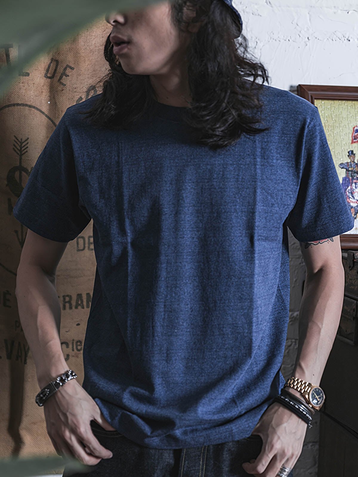 モデルがライトブルーのデニムジーンズと白いキャンバスシューズを合わせたヘビーウェイト半袖Tシャツを着用。カジュアルで個性的な日常のスタイルを展示している。