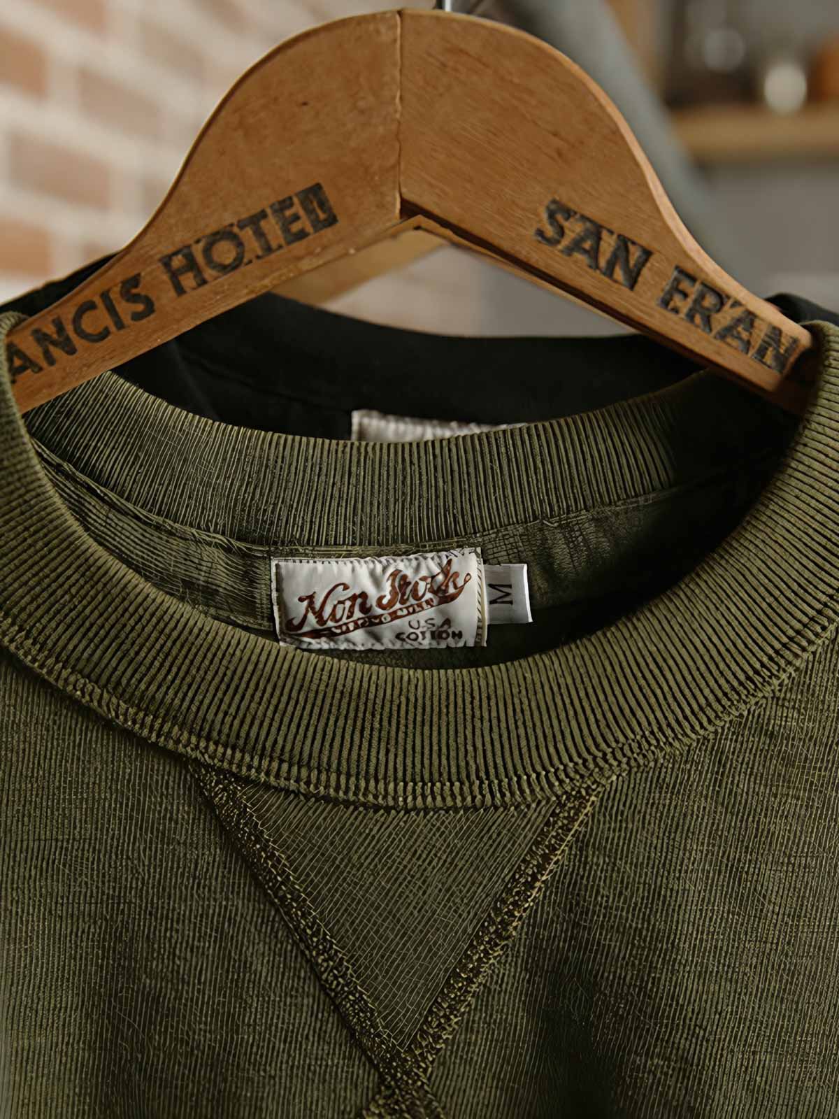 300GピュアコットンTシャツの首元のV字ディテールと生地の竹節効果のクローズアップ。耐久性とスタイルが見て取れる。