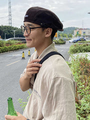 カジュアルかつ洗練されたコーデュロイのベレー帽を着用するモデル。フロントの刺繍がシンプルながらも強い個性を表現している。