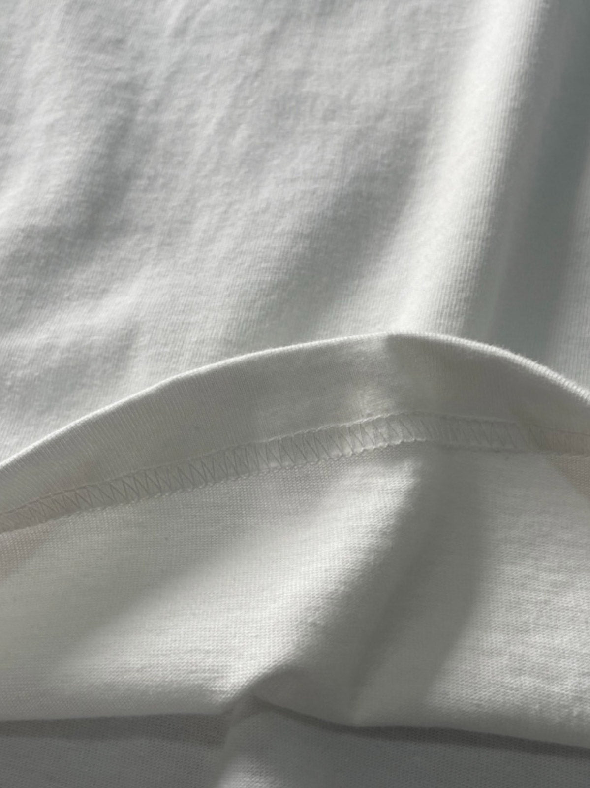 製品画像: クラシックヘンリーネックTシャツのフロント展示 詳細画像: リブネックと縫製ディテールの展示