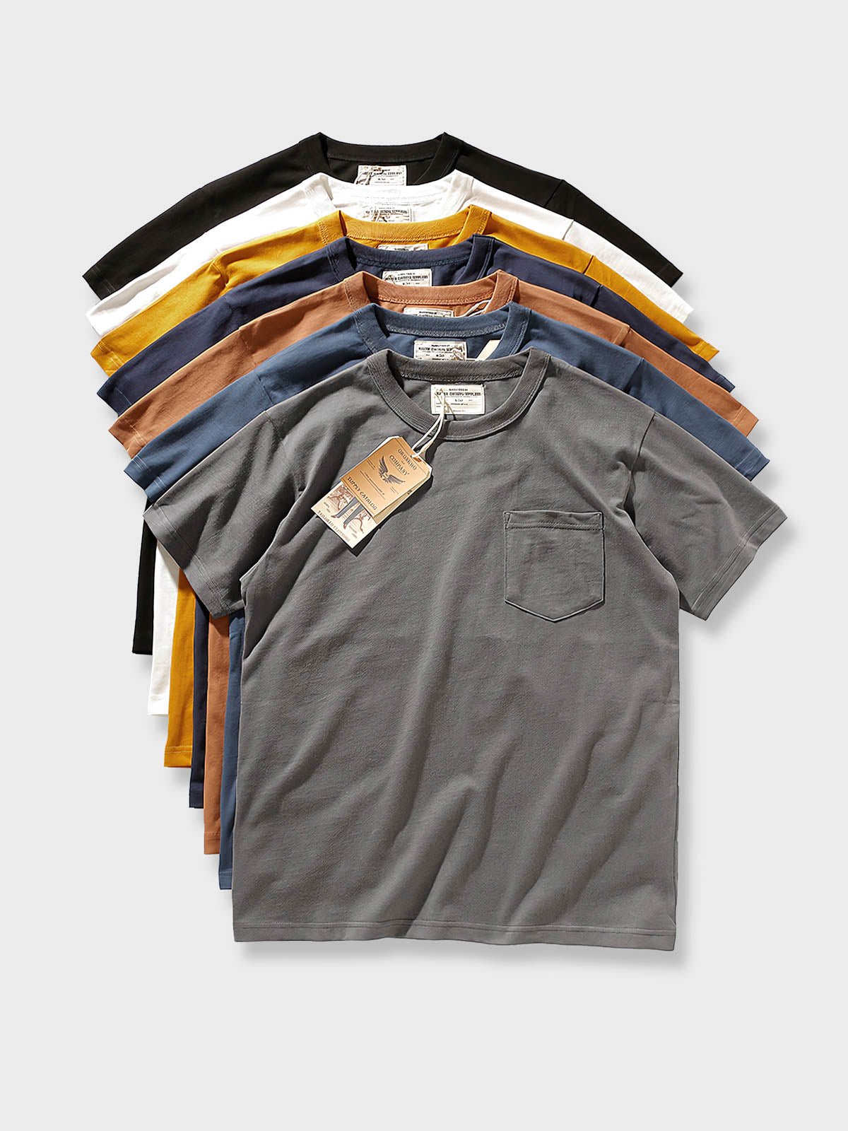 ポケット付きTシャツのクローズアップ。精巧なリブ編みネックラインとトリプルステッチが細部へのこだわりを示し、着心地と耐久性を強調しています。