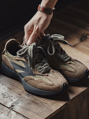 スモークオリーブ色クラシック70年代ジョギングシューズの構造図、本革スエードと通気性デザインを示す