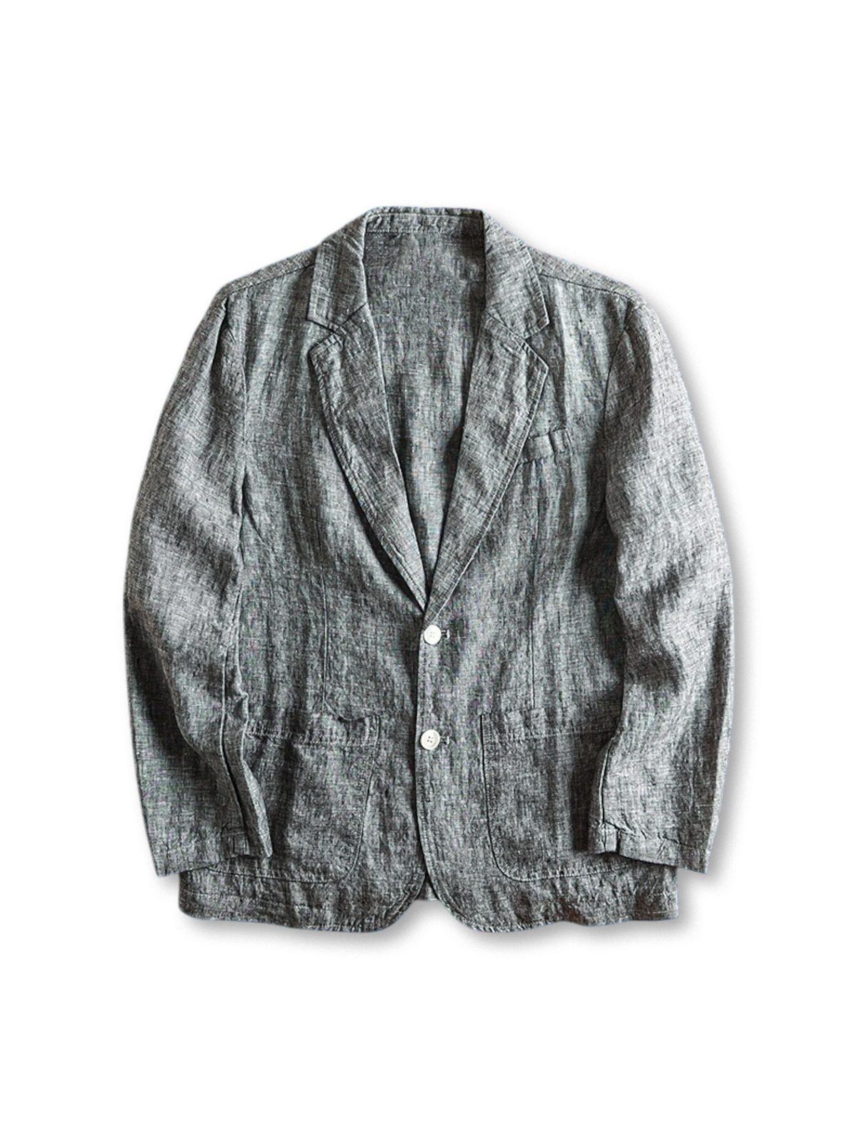 ウォッシュ加工されたリネン素材のテーラードジャケット、フロントに二つボタンとパッチポケッ