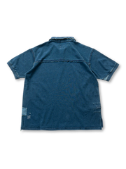 製品画像: インディゴ染めがほどよく色落ちしたポロシャツ全体像、補丁や刺繍がアクセント
