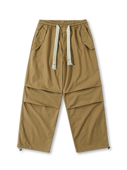  ブラックのパラシュートパンツ、両サイドに大きなフラップポケットを配したデザイン