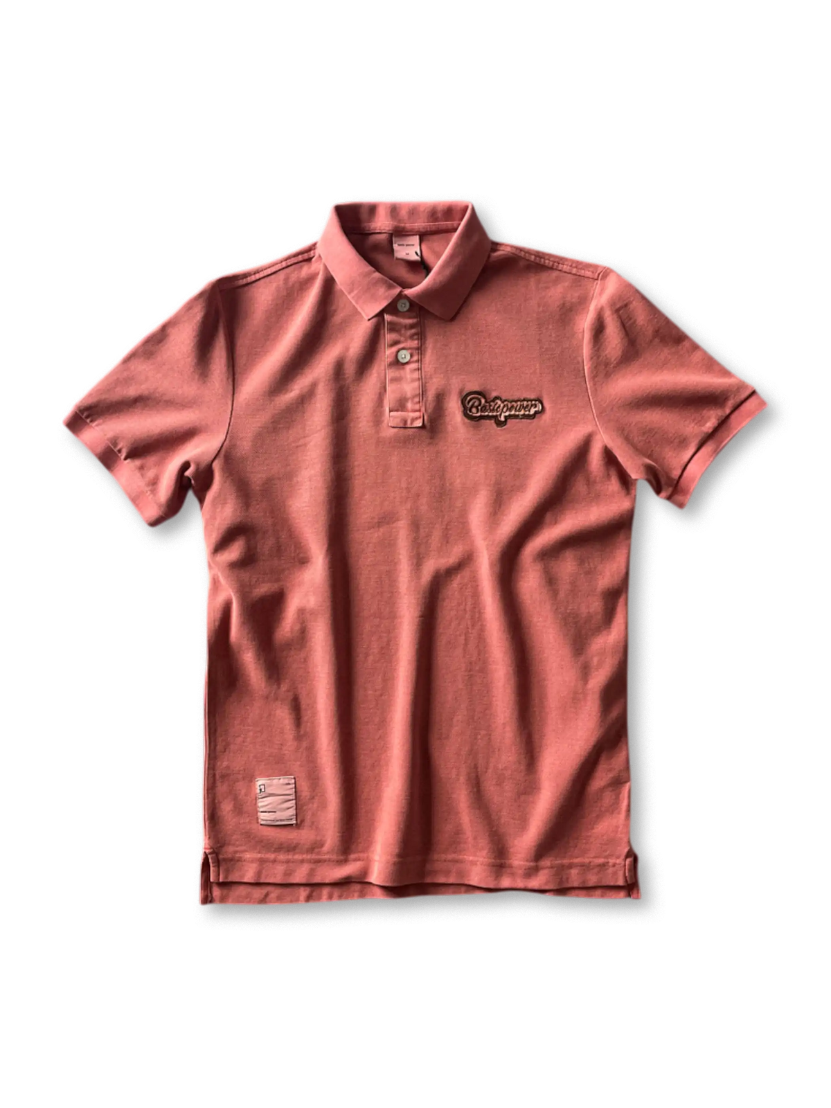 ヴィンテージウォッシュが施されたポロシャツ、胸元の刺繍ロゴが見える