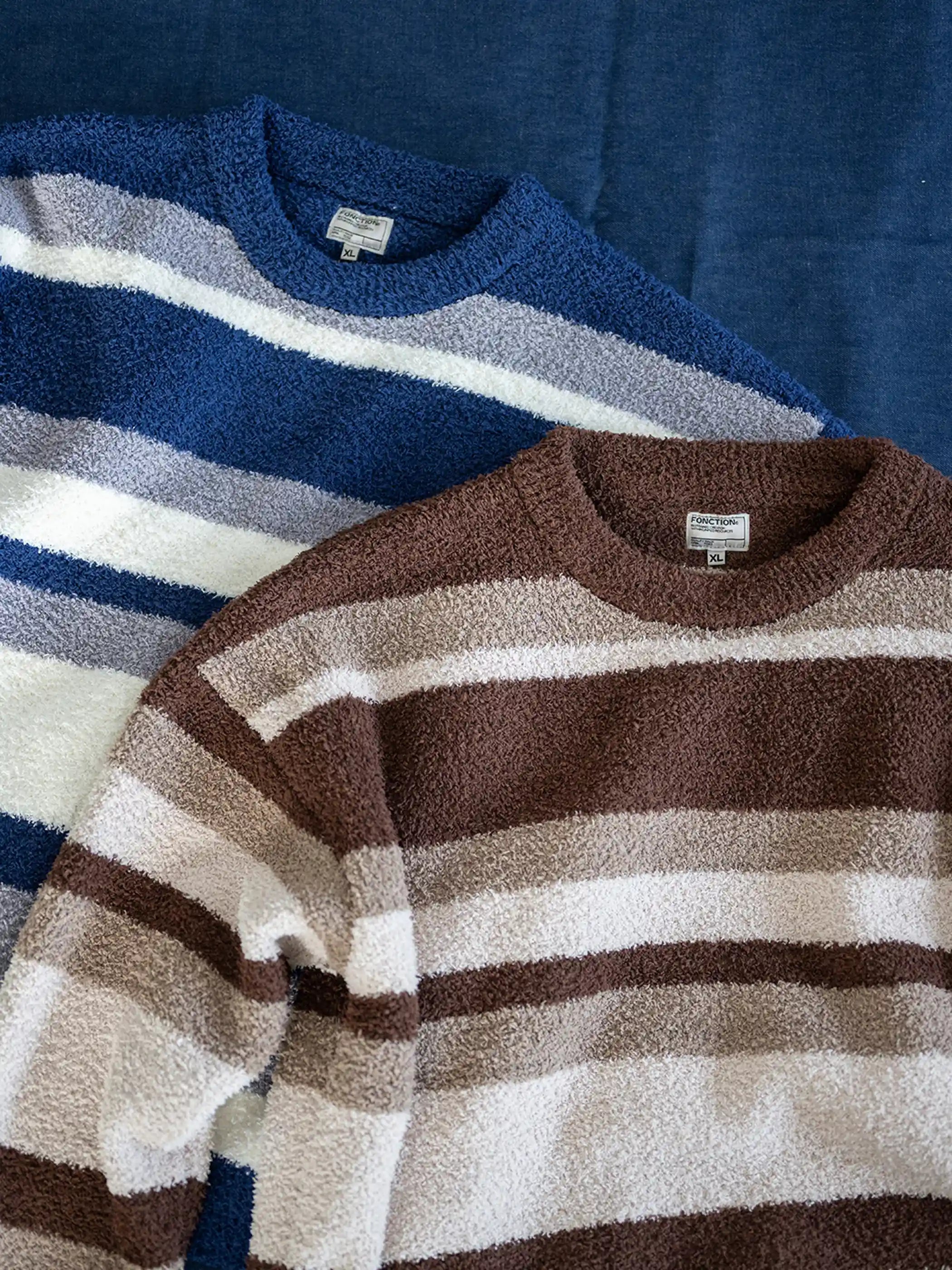 短丈ワイドシルエットのストライプニット、微起毛感のある半边フリース素材。詳細画像：袖口・裾のリブ仕様やブルー系/ブラウン系の不規則ストライプ。モデル画像：モデルがレイヤードスタイルで着用し、レトロモダンな雰囲気を演出。