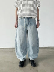 淡いウォッシュ加工が施されたロング丈ワイドデニム、ウエストのドローコードが見える
