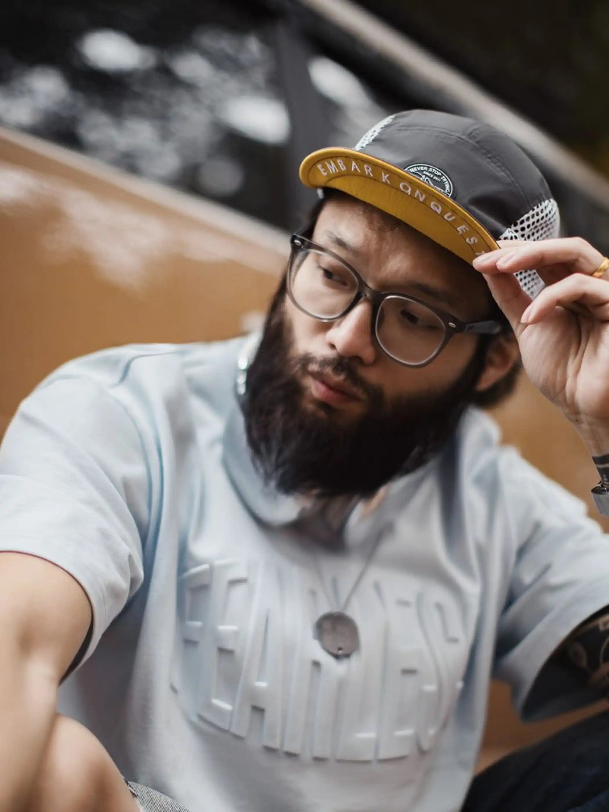 メッシュパネルがサイドに施された5パネルキャップ、フロントにラウンド型のワッペン