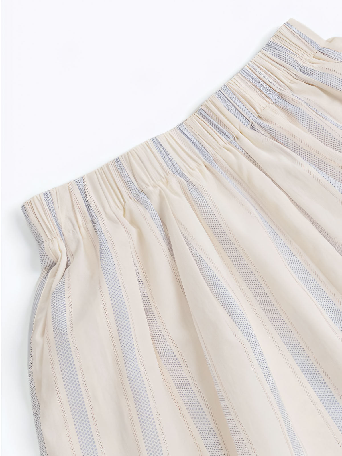 詳細画像: ストライプセットアップの詳細図。ピークドラペルデザインとワイドレッグショートパンツのゴムウエストデザインを展示。