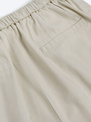 詳細画像: シンプルなライトベージュのドローストリングウエストワイドレッグパンツの詳細図。ドローストリングウエストとポケットデザインを展示。