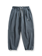 製品画像: 4色展開 カジュアル スウェットパンツ。裏起毛素材とルーズフィットデザインを採用した、冬に最適な厚手スウェットパンツの正面全体展示図。

詳細画像: 柔らかい裏起毛素材の質感と、冷気を防ぐ裾のリブデザインのディテールクローズアップ。